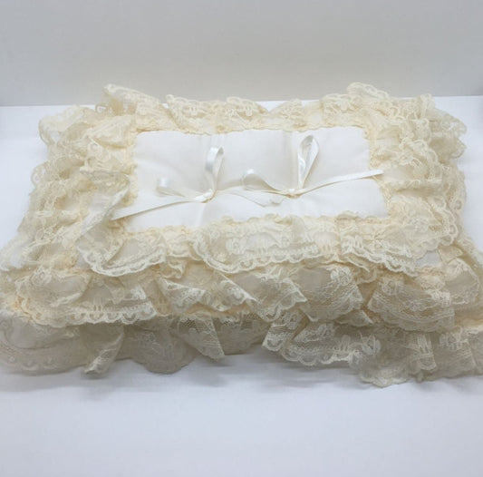 Cuscino rettangolare portafedi lavorato con 3 linee di pizzo. Colore: ecrù. Dimensioni: cm 32 x 24. In negozio e online su tuttochic.live