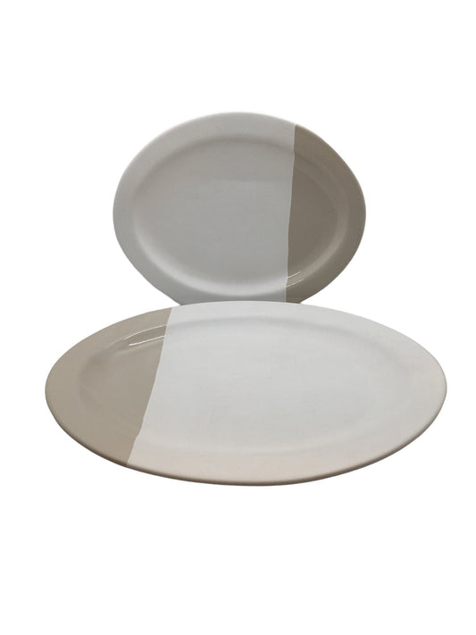 Set 2 piatti ovali in ceramica, di colore avorio con fascia color tortora. Dimensioni: grande cm 31,5 x 25,5, piccolo cm 25 x 20,5. realizzato a mano, differenze di colore, irregolarità ed imperfezioni non sono da considerarsi difetti ma caratteristiche tipiche di questa lavorazione. In negozio e online su tuttochic.live