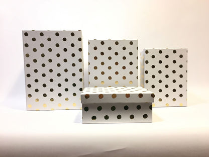 Set di 4 scatole regalo rettangolari in cartone bianco con decorazione pois color oro. Dimensioni: scatola piccola cm 18 x 13 x 7,7 h scatola media cm 20 x 14,5 x 8,5 h scatola grande cm 23 x 16,5 x 10,4 h scatola maxi cm 26 x 18,5 x 12 h. In negozio e online su tuttochic.live