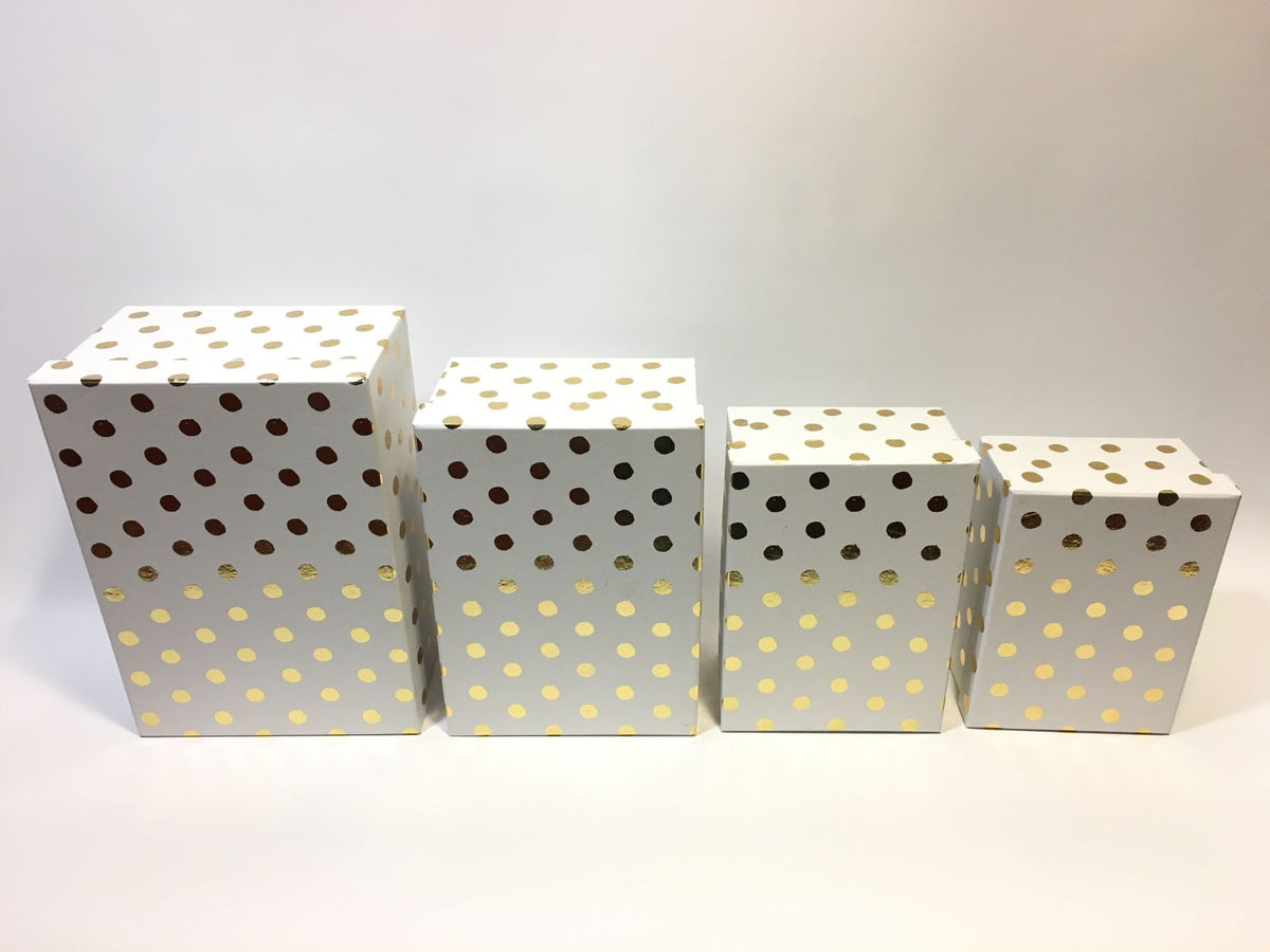 Set di 4 scatole regalo rettangolari in cartone bianco con decorazione pois color oro. Dimensioni: scatola piccola cm 18 x 13 x 7,7 h scatola media cm 20 x 14,5 x 8,5 h scatola grande cm 23 x 16,5 x 10,4 h scatola maxi cm 26 x 18,5 x 12 h. In negozio e online su tuttochic.live